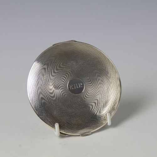 23 - A George V silver mounted compact, 'SF' London 1933, of circular form with all over engine turned de... 