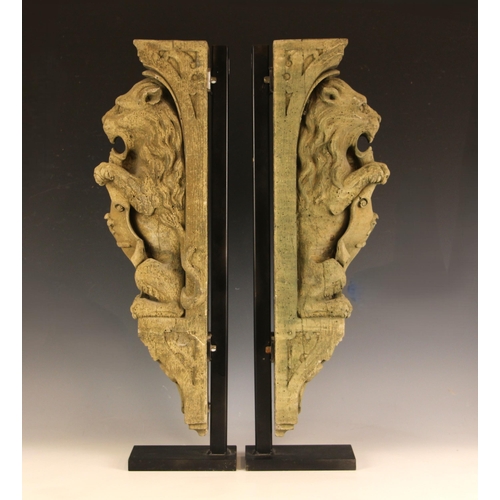 377 - A pair of reconstituted stone corbels, late 20th century, each modelled as rampant lion bearing a sc... 