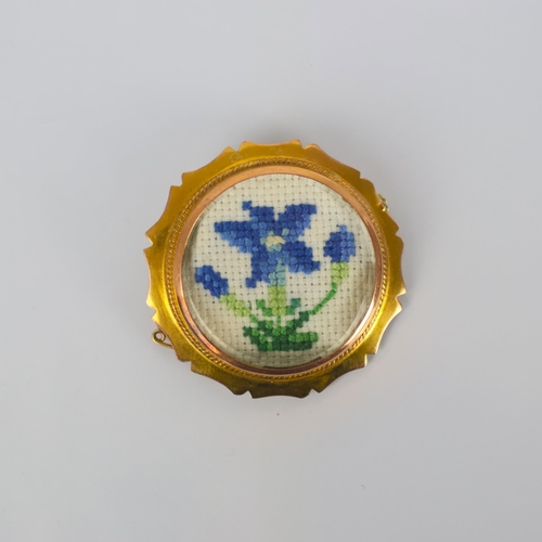 123 - An early 20th century yellow metal brooch, the shaped circular yellow metal mount encompassing later... 