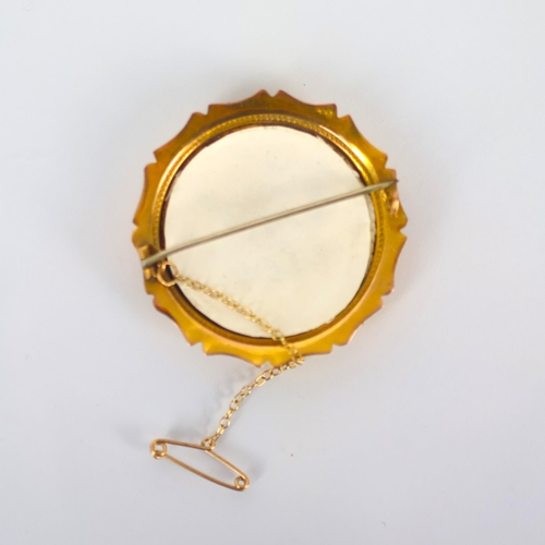 123 - An early 20th century yellow metal brooch, the shaped circular yellow metal mount encompassing later... 