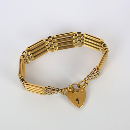 124 - A late 20th century 9ct gold bracelet, the stylised gate link bracelet suspending a heart shaped pad... 
