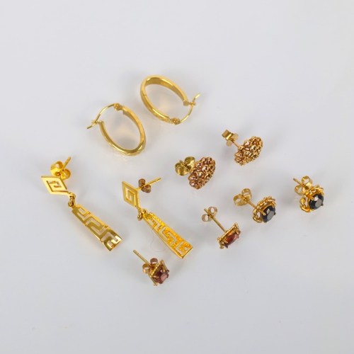 132 - A selection of yellow metal and gold coloured earrings, including a pair of hoop earrings, stamped '... 