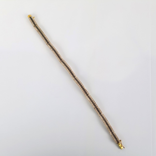 139 - A late 20th century yellow metal diamond bracelet, the wide panelled bracelet set with central row o... 