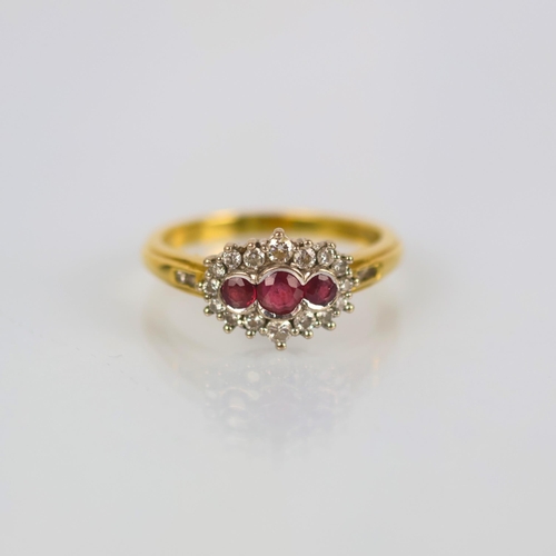 142 - A late 20th century 18ct yellow gold ruby and diamond dress ring, the central trio of round cut rubi... 