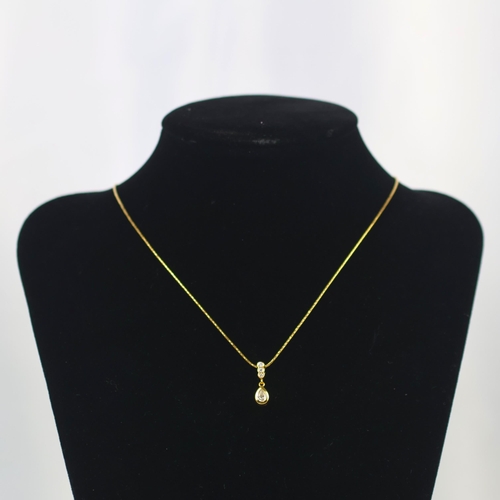 143 - A late 20th century 18ct yellow gold diamond pendant, the central pear cut diamond within rub over m... 