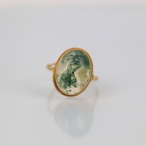 145 - A late 20th century 9ct gold moss agate ring, the oval cabochon moss agate set in rub over mount wit... 