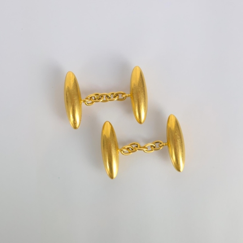 155 - A pair of early 20th century yellow metal cufflinks, the torpedo shaped cufflinks with trace link ch... 