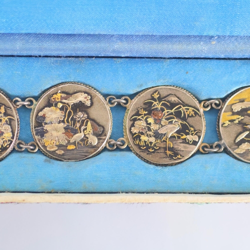 160 - A mid 20th century Japanese Shakudo bracelet, the six circular panels depicting scenes of cranes amo... 