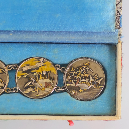 160 - A mid 20th century Japanese Shakudo bracelet, the six circular panels depicting scenes of cranes amo... 
