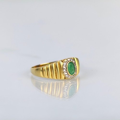 162 - A late 20th century emerald and diamond ring, the central oval cut emerald within surround of round ... 