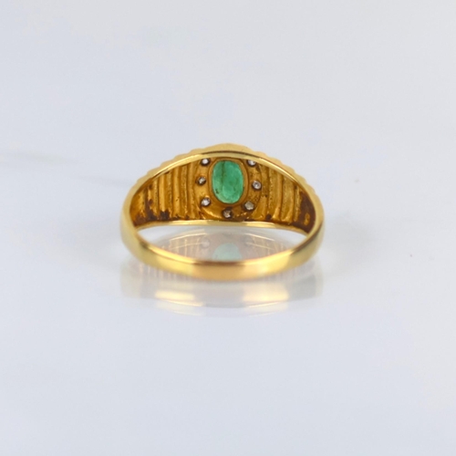 162 - A late 20th century emerald and diamond ring, the central oval cut emerald within surround of round ... 