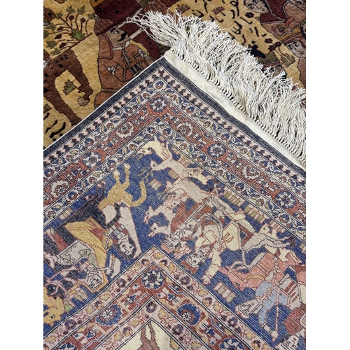 476 - A Persian Tabriz pictorial silk rug, the central field decorated with processions of warriors and ku... 