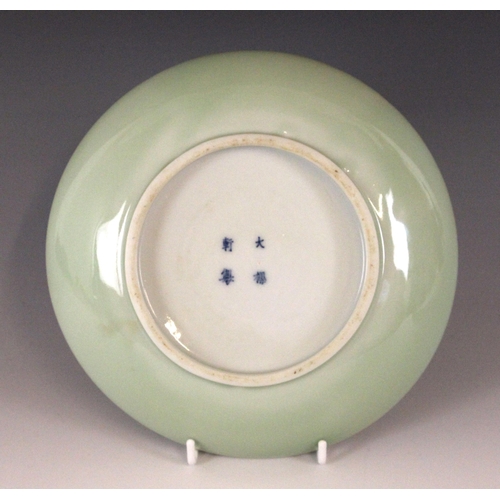 348 - A Chinese celadon-ground famille rose dish, 19th century, of circular form and panted to the centre ... 
