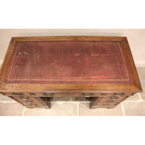 589A - An Edwardian oak twin pedestal desk, the top with tooled leather skiver (at fault) below a central l... 