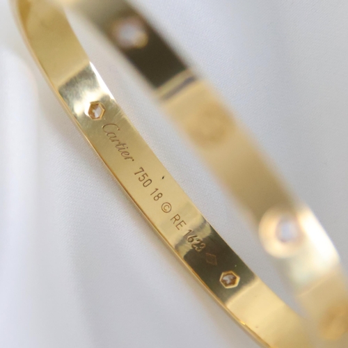95 - A 'Cartier Love' bangle, the yellow gold bangle set with alternating screw head motifs and four diam... 