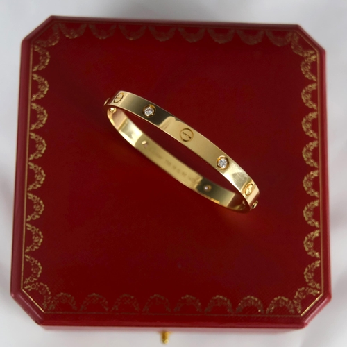 95 - A 'Cartier Love' bangle, the yellow gold bangle set with alternating screw head motifs and four diam... 