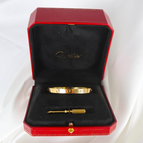 95 - A 'Cartier Love' bangle, the yellow gold bangle set with alternating screw head motifs and four diam... 