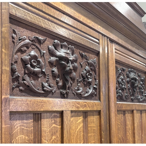 564 - A Victorian oak gentleman's compactum wardrobe, the pair of paneled and carved doors with inset foli... 