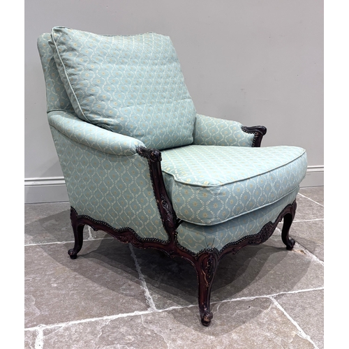 575 - A Louis XV style carved walnut fauteuil, upholstered in a green and gold trellis design fabric, with... 