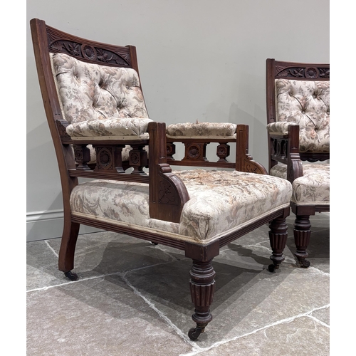 581 - A pair of Victorian carved walnut library armchairs, each carved with floral motifs and aesthetic sp... 