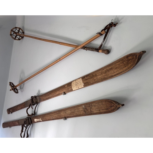 389 - A pair of Vintage skis, early 20th century, 212cm long, with associated poles (4) (at fault)