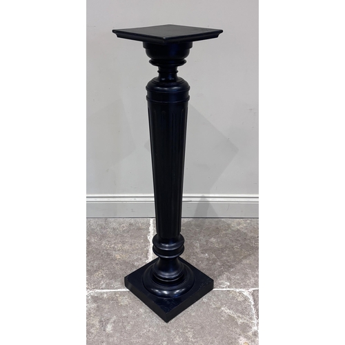 553 - A 19th century stye ebonised torchere, the fluted turned, column raised on a square plinth base with... 