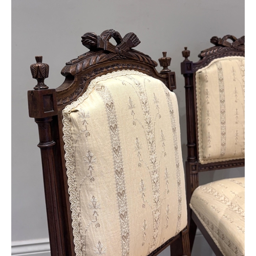 555 - A pair of Louis XVI style walnut side chairs, circa 1880, the carved frames with torch and quiver ra... 