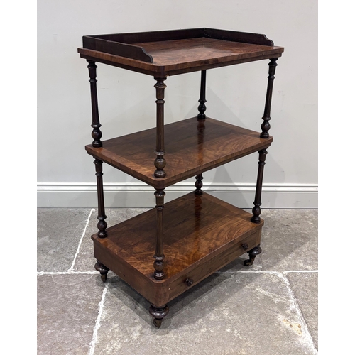 563 - A Victorian walnut etagere or what-not, of three tier form with single drawer to base, raised on cas... 