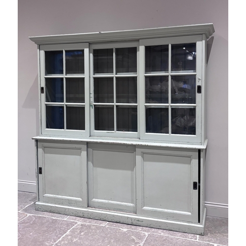 561 - A large Victorian painted pine housekeeper's cupboard, the top section with two sliding glazed doors... 