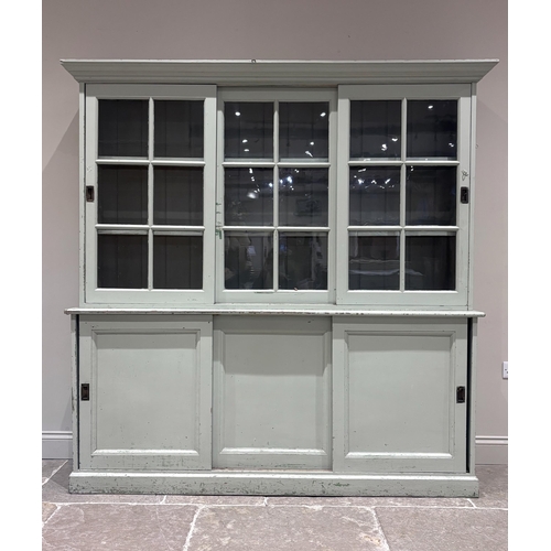 561 - A large Victorian painted pine housekeeper's cupboard, the top section with two sliding glazed doors... 