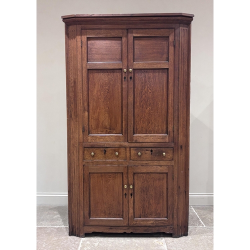 544 - A George III oak floor standing, full height corner cupboard, the upper section formed as a pair of ... 