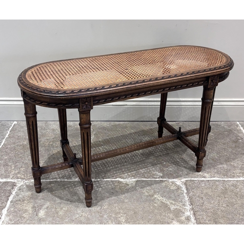 556 - A Louis XVI style long stool, 20th century, the oval top set with bergere caning, above six turned a... 