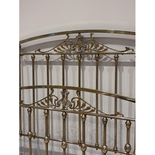577 - An Art Nouveau lacquered brass double bed frame, the head and foot with spindle supports above an ar... 