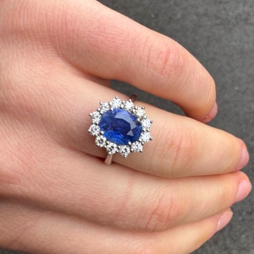 135 - A mid 20th century certified sapphire and diamond cluster ring, circa 1960, the oval sapphire within... 