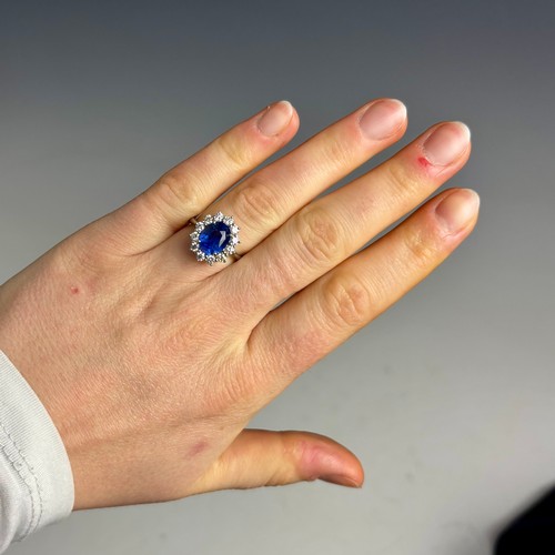 135 - A mid 20th century certified sapphire and diamond cluster ring, circa 1960, the oval sapphire within... 