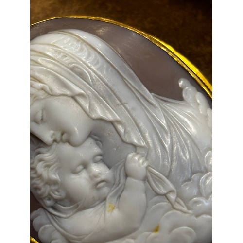115 - A 19th century Italian cameo brooch, the central oval depiction of the Madonna with child, within a ... 