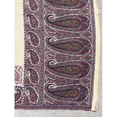 398 - A 19th century finely woven Kashmir style paisley shawl, in ivory with a paisley pattern border, fri... 
