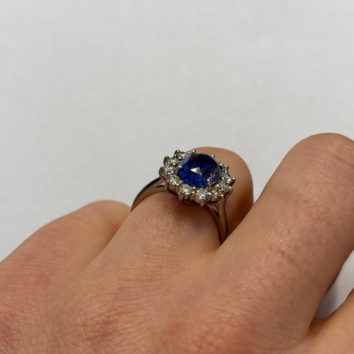 135 - A mid 20th century certified sapphire and diamond cluster ring, circa 1960, the oval sapphire within... 