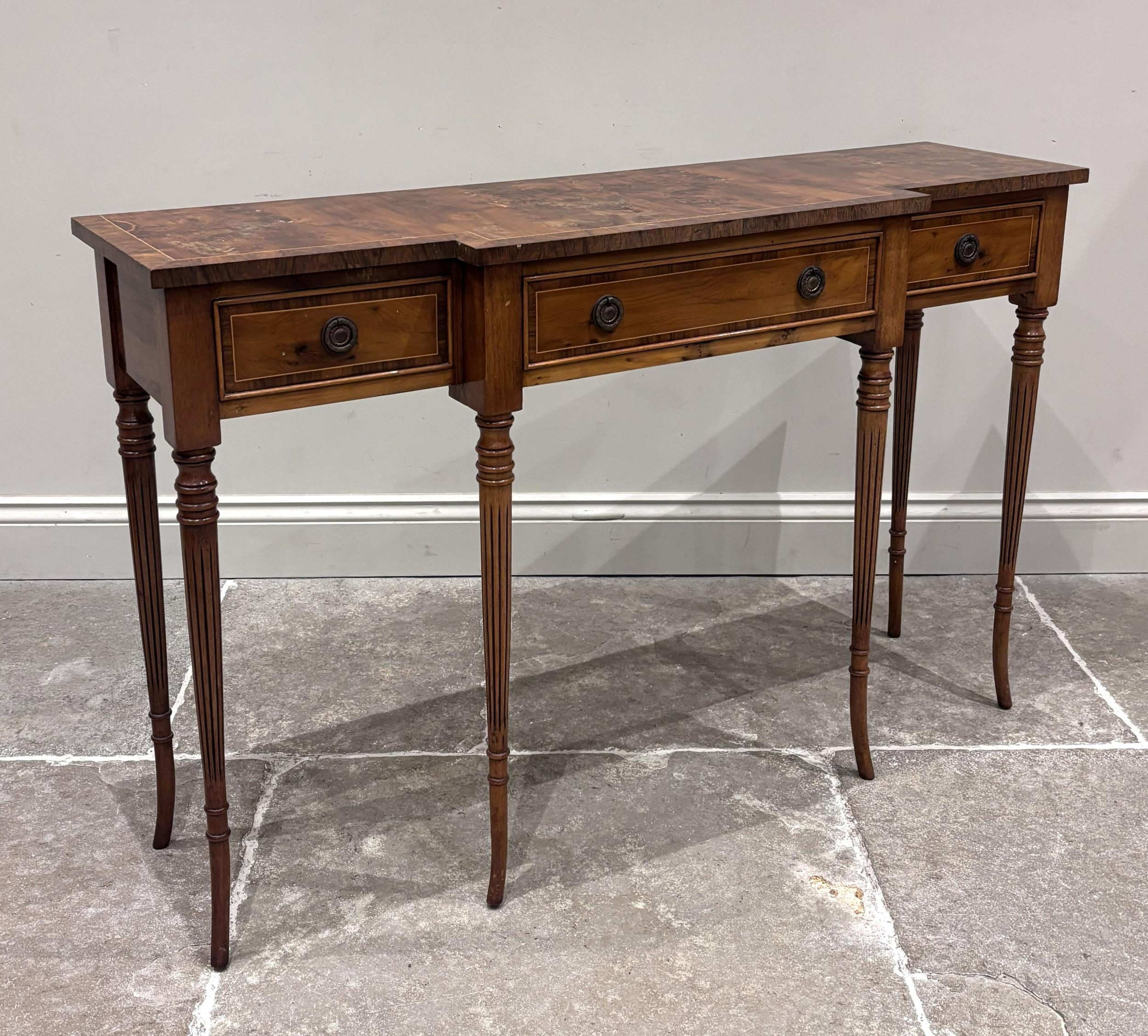 A Regency style burr wood console table, the breakfront with a central ...