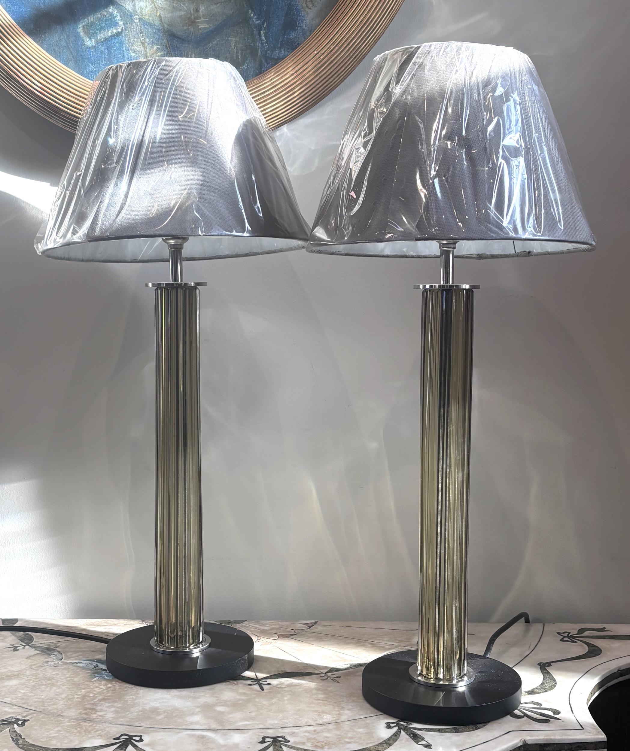 A contemporary pair of glass column table lights, each column of fluted ...