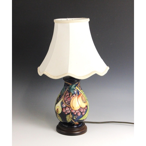391 - A Moorcroft table lamp in the 'Queens Choice' patterned designed by Emma Bossons, of baluster form, ... 