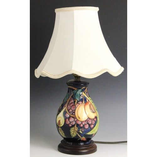391 - A Moorcroft table lamp in the 'Queens Choice' patterned designed by Emma Bossons, of baluster form, ... 