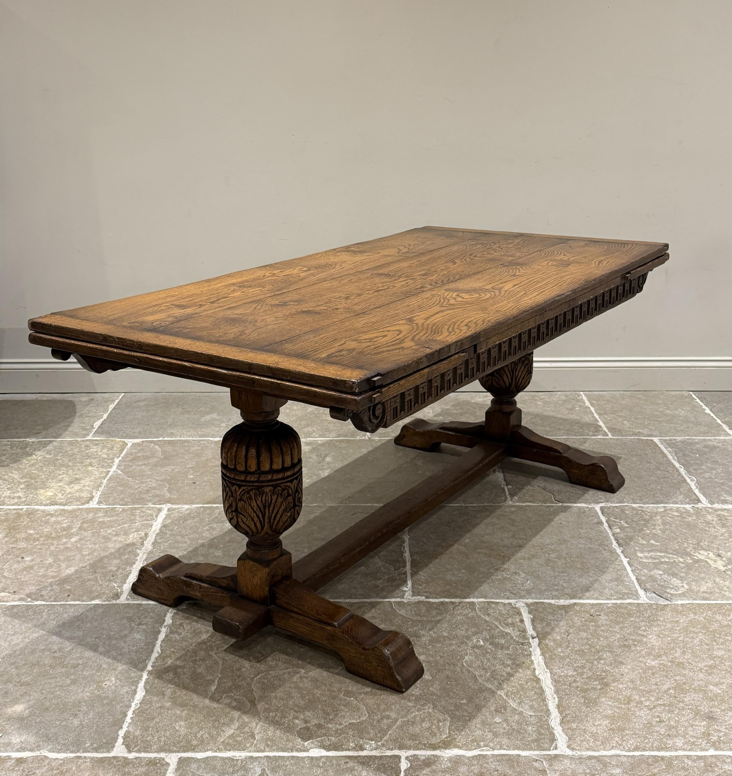 An oak extending refectory table in Carolean style, the three plank top ...