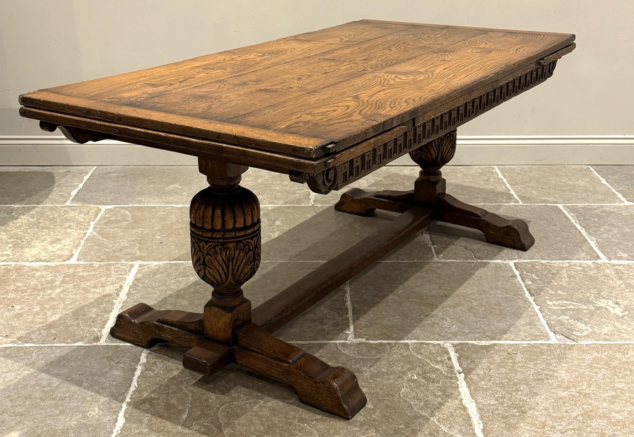 An oak extending refectory table in Carolean style, the three plank top ...