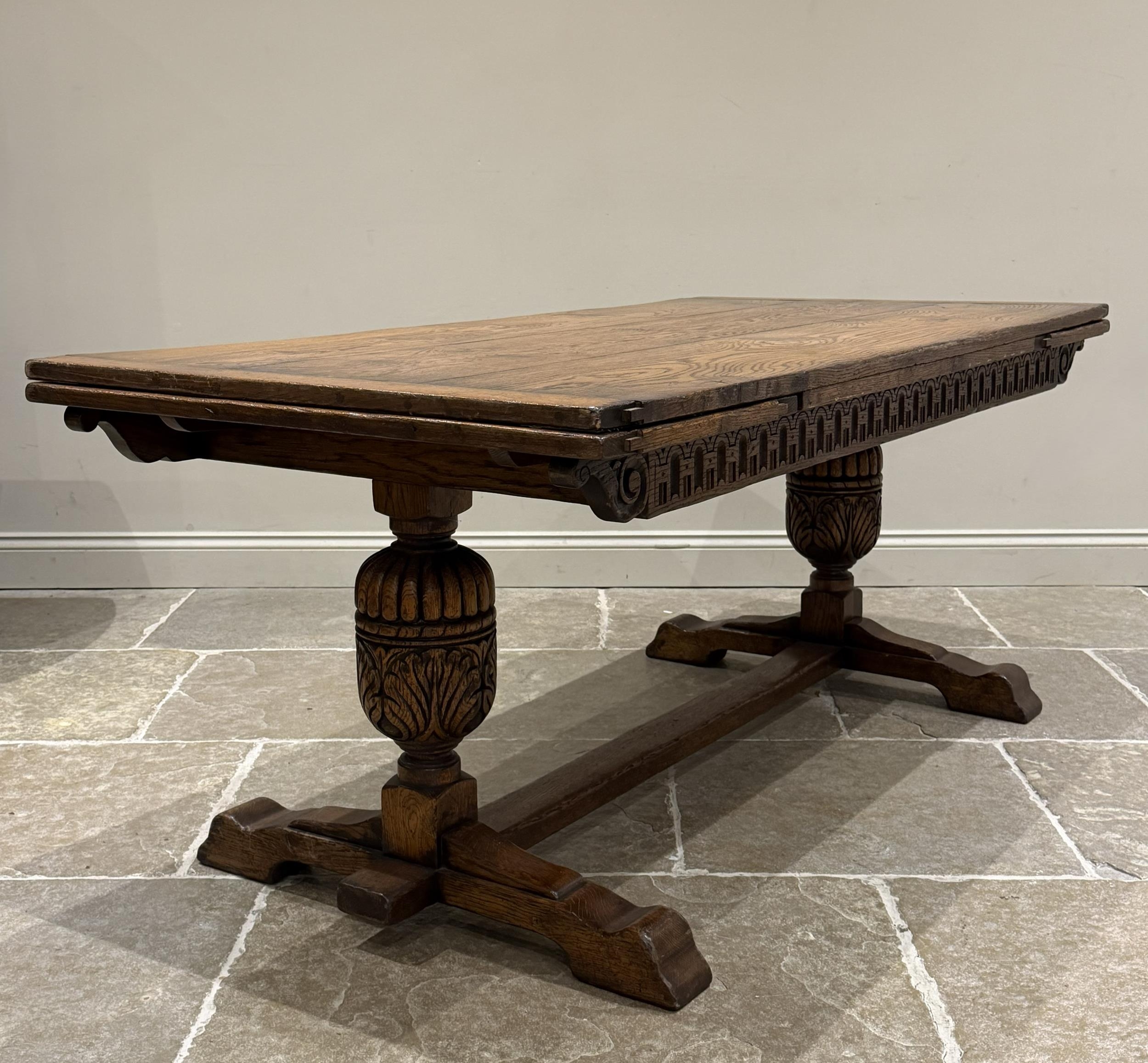 An oak extending refectory table in Carolean style, the three plank top ...