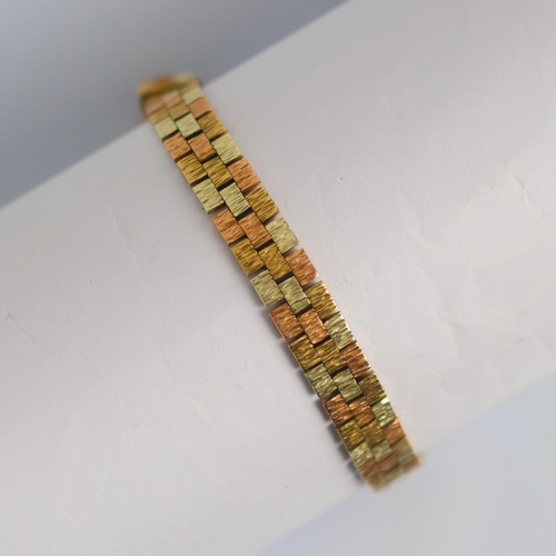 176 - A late 20th century three tone bracelet, the brick link style bracelet with textured design, hidden ... 