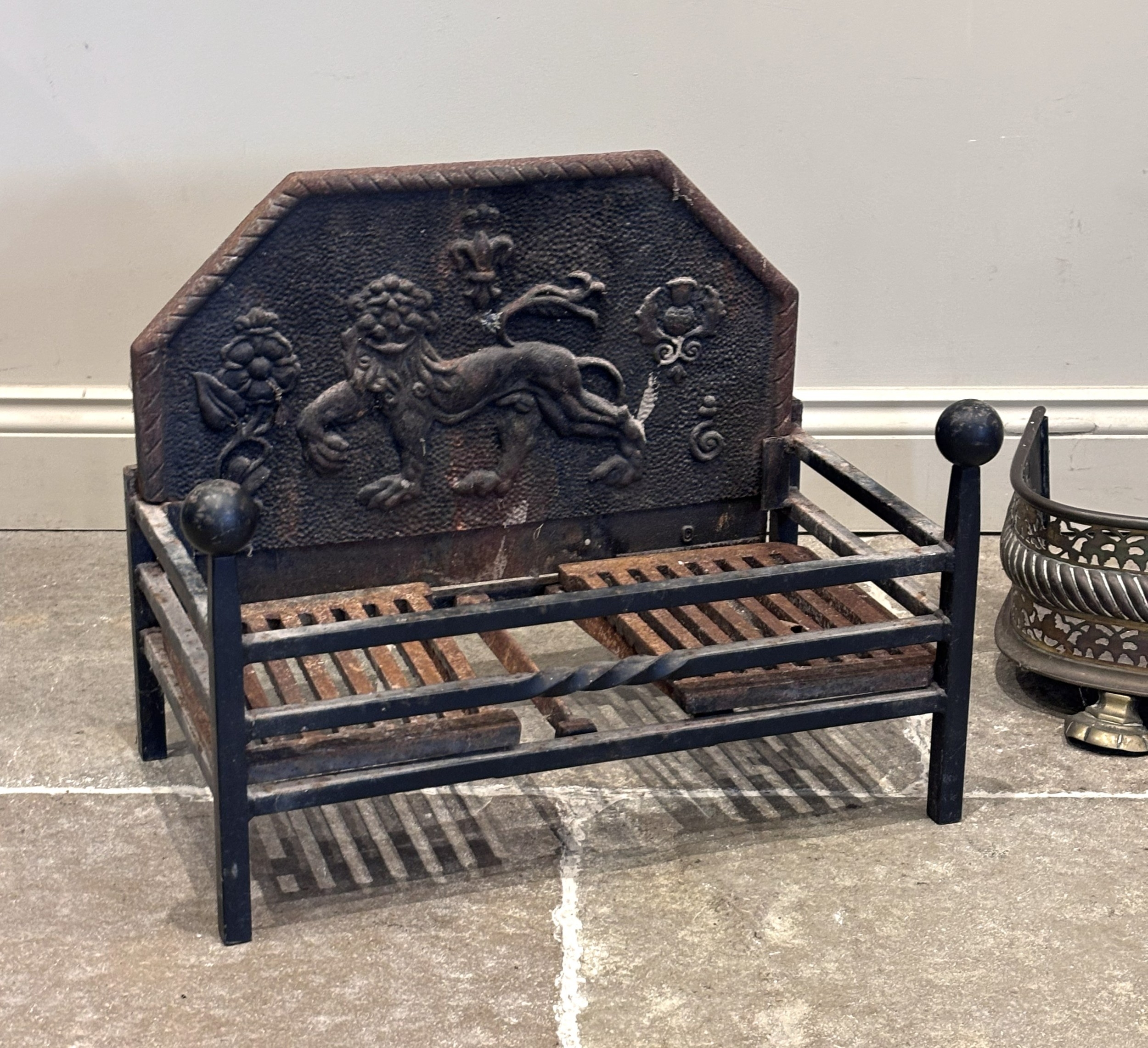A 19th century cast iron fire back, depicting a lion amidst a Tudor ...