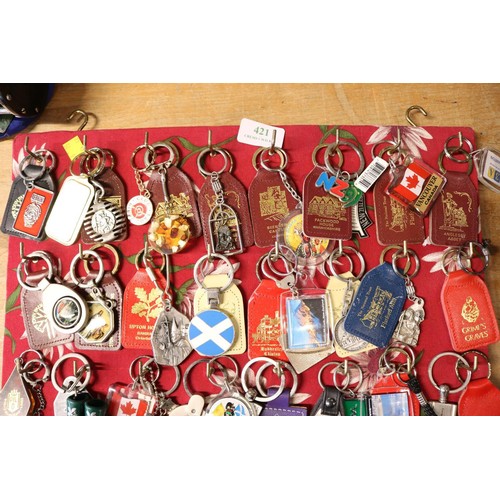 421 - Board full of keyrings (approx 65)