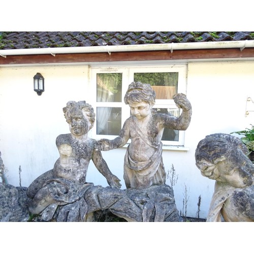 827 - Large carved ornament depicting 6 children playing on rocks a/f approximately 2.79 m wide