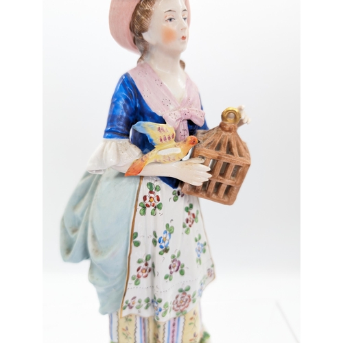 305 - Sitzendorf Porcelain Figure With Bird and Cage, Has a Loss to Wing.
25cm